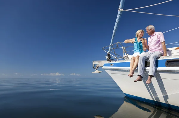 En glad äldre paret som sitter på framsidan av en segelbåt Stockfoto