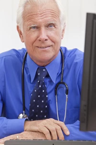 高级男性医生用听诊器在桌子 & 计算机 — 图库照片