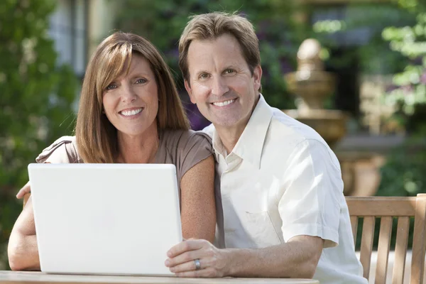 Coppia uomo & donna che utilizza computer portatile in giardino — Foto Stock