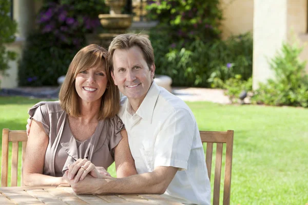 Мужская и женатая пара, сидящая в саду — стоковое фото