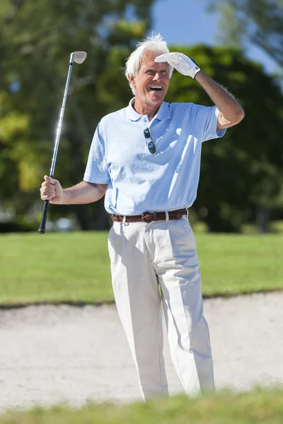 Hombre mayor feliz jugando golf en Bunker Imagen de stock