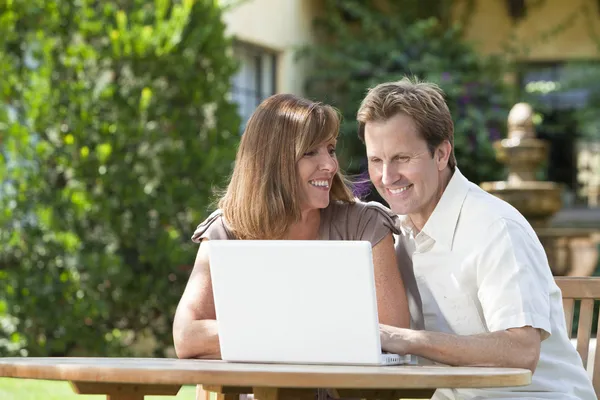 Man & Woman Couple Using Laptop Computer In Garden Royalty Free Stock Photos