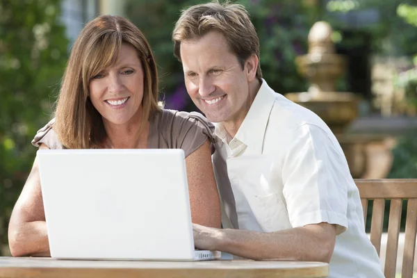 Man & Woman Couple Using Laptop Computer In Garden Royalty Free Stock Images