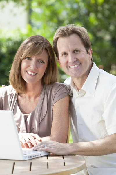 Man & Woman Couple Using Laptop Computer In Garden Stock Photo