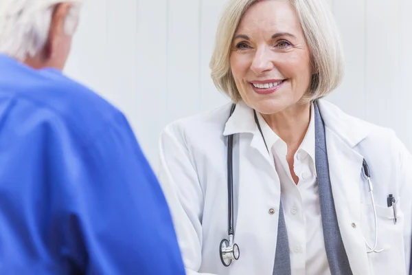 Gelukkig lachend senior koppel zittend op een park bench omarmen — Stockfoto