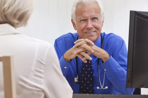 Gelukkig lachend senior koppel zittend op een park bench omarmen — Stockfoto