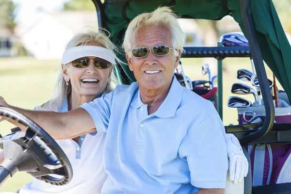 Starší pár, hrát golf driving vozík buggy — Stock fotografie