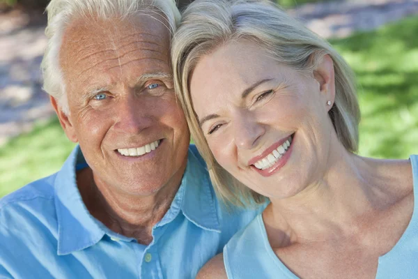 Feliz pareja de ancianos sonriendo afuera bajo el sol — Foto de Stock