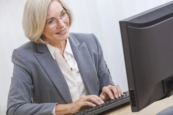 Seniorin nutzt Computer — Stockfoto