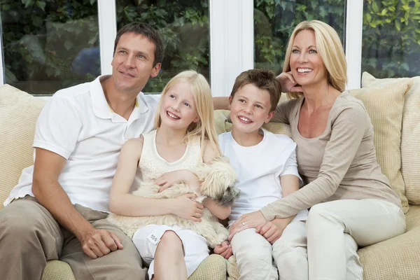 Glückliche Familie hat Spaß zu Hause mit Hund sitzen — Stockfoto