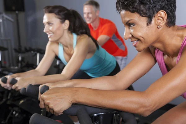 Africano americano mulher girando bicicleta de exercício no ginásio — Fotografia de Stock