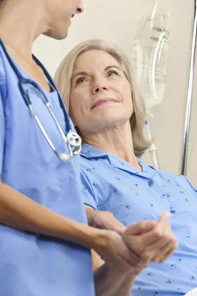 Äldre kvinnlig Patient i sjukhussäng & kvinna läkare — Stockfoto