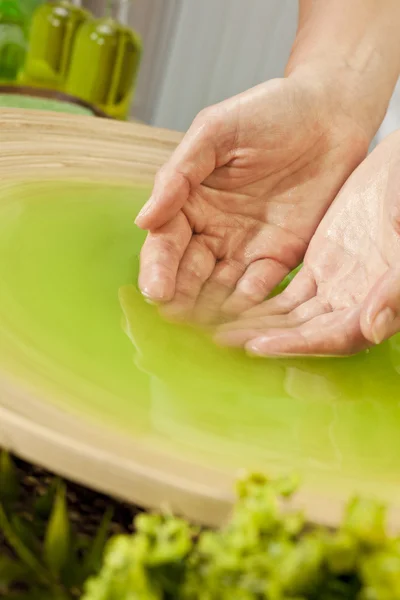 Woman's Hands in Green Liquid at Health Spa — Stock Photo, Image