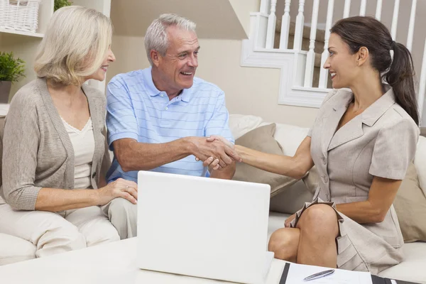 Saleswoman Shaking Hands With Senior Couple at Home Royalty Free Stock Photos
