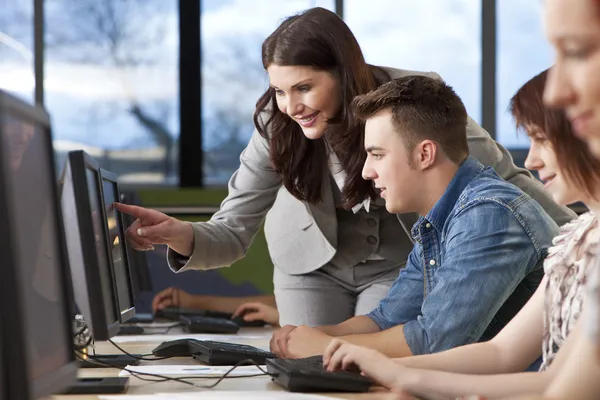 Schüler und Lehrer nutzen Computer an der Hochschule lizenzfreie Stockfotos