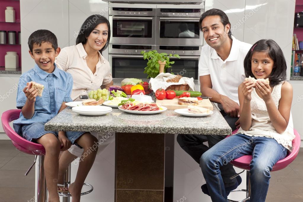 Asiático indio padres niños familia comiendo comida saludable en kitc 2023
