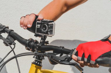 Bir adam bisikletin gidonuna kamera koyar.