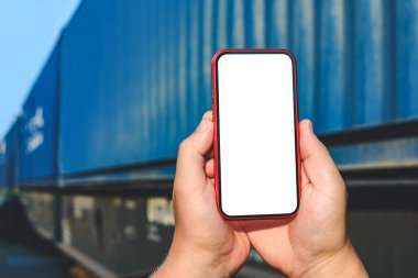 Erkek ellerindeki telefon modeli. Bir tren vagonunun arka planında