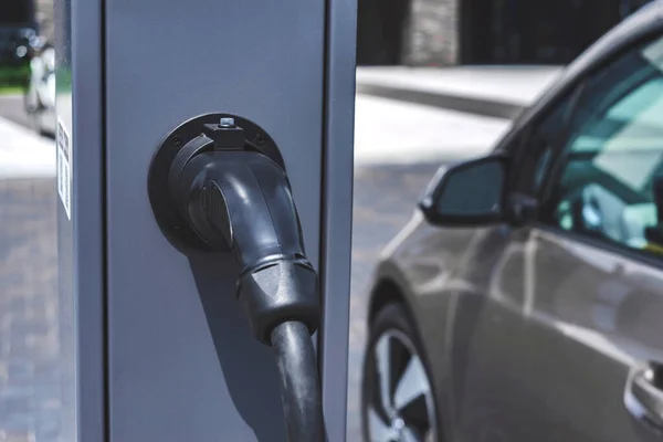 Yakın plan, istasyon için güç kaynağı, elektrikli araçları şarj etmek. Arabanın arka planında.