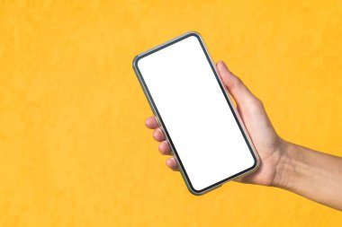 Yakın plan, bir kızın elindeki akıllı telefonun maketi. Dekoratif alçıdan yapılmış sarı bir cephede