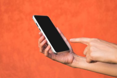 Parmağını telefonun önüne, kızın eline koy. Dekoratif alçıdan yapılmış turuncu bir cephede