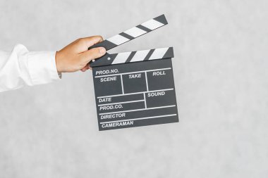 Yönetmenin el çırpma tahtası bir adamın elinde. Hafif bir arkaplanda