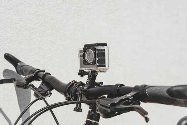 Close Impermeável Câmera Ação Guidão Uma Bicicleta Fundo Parede Leve — Fotografia de Stock