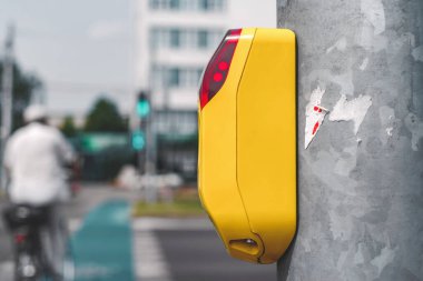 Trafik lambasından geçen bir yayanın yakın çekimi. İnsanların arka planına ve yeşile karşı