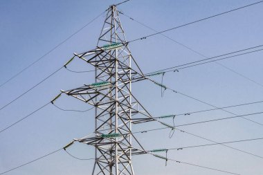 Elektrik hatları ve kuleler. Modern bir yüksek voltaj güç sistemi. Mavi gökyüzünün arka planında