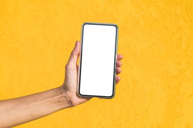 Yakın plan, bir kızın elindeki akıllı telefonun maketi. Dekoratif alçıdan yapılmış sarı bir cephede