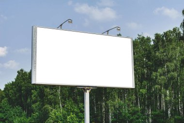 Beyaz ekranlı boş reklam panosu modeli. Doğanın ve mavi gökyüzünün arka planına karşı. İş konsepti. Reklam için boşluk afişini kopyala
