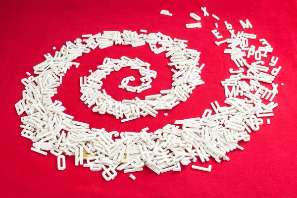 Lettere dimensionali sparse a spirale su sfondo rosso — Foto Stock