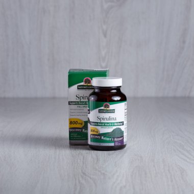 Kamianets-Podilskyi, Ukrayna, 7 Mart 2022, Koyu yeşil bir ilaç şişesi. Ön taraftaki küçük yeşil kapsüller. Doğanın cevap paketi spirulina.. 