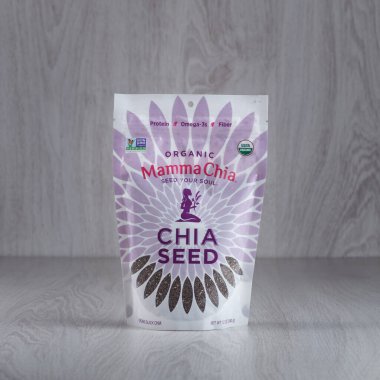 Kamianets-Podilskyi, Ukrayna, 15 Mart 2022: Ahşap arka planda açık mor bir chia tohumu paketi. Organik chia tohumları.