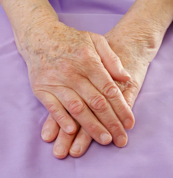 Old hands on bed — Stock Photo, Image