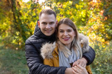 Mutlu genç çift dışarıda sarılıp gülüyor.