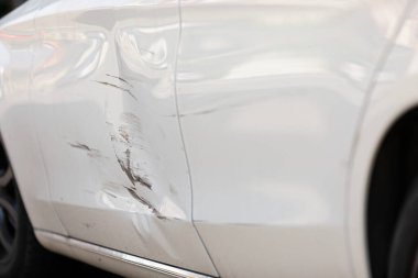 Küçük bir kazadan sonra beyaz arabanın kapısındaki hasarı kapat.