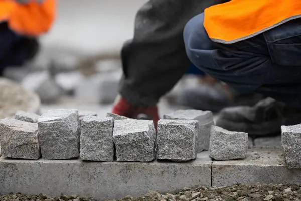 Seorang Pria Berseragam Meletakkan Batu Bata Pinggir Jalan Lokasi Konstruksi — Stok Foto
