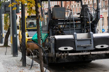 Endüstriyel kaldırım makinesi sokaklara taze asfalt seriyor. 