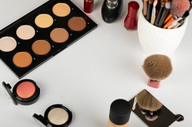Makyaj ürünlerinin ve aksesuarların, kontur paletinin, beyaz arkaplanda fırçaların resmini kapat 