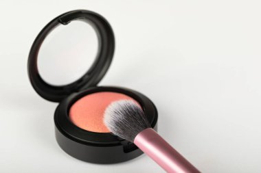 Beyaz arkaplanda gül sarısı ve makyaj fırçası resmi