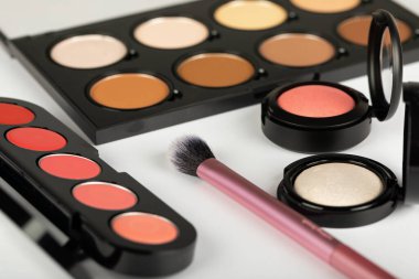 Makyaj ürünlerinin ve aksesuarların, kontur paletinin, beyaz arkaplanda fırçaların resmini kapat 