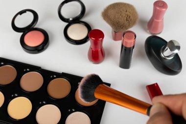 Makyaj ürünlerinin ve aksesuarların, kontur paletinin, beyaz arkaplanda fırçaların resmini kapat 