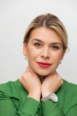 Beyaz arka plandaki kameraya bakan güzel bir kadının portresi.