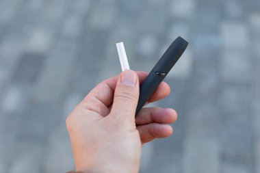 Elektrikli sigara tutan bir adamın resmi.