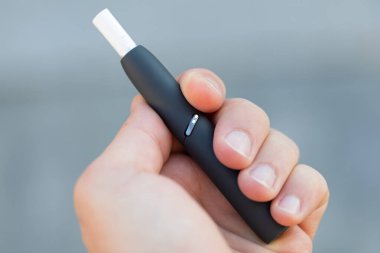 Elektrikli sigara tutan bir adamın resmi.