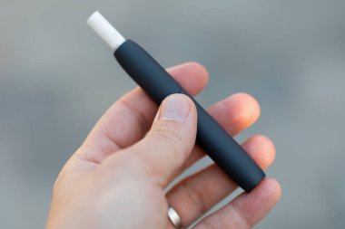 Elektrikli sigara tutan bir adamın resmi.