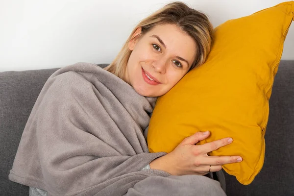 季節性インフルエンザで若い女性の方が Balnket に包まれたソファに横になっている頭痛や発熱が持つ — ストック写真