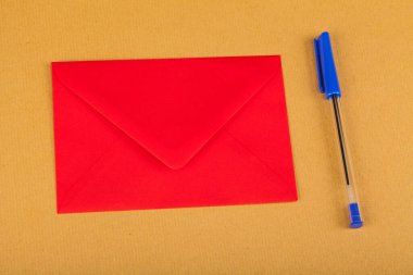 Sarı zemin üzerinde kalem olan kırmızı zarf.