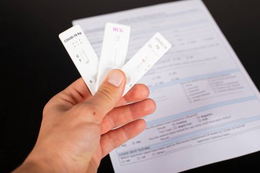 Coronavirus testi ve balkon arka planında tıbbi evrakları tutan adamın fotoğrafını kapat. 